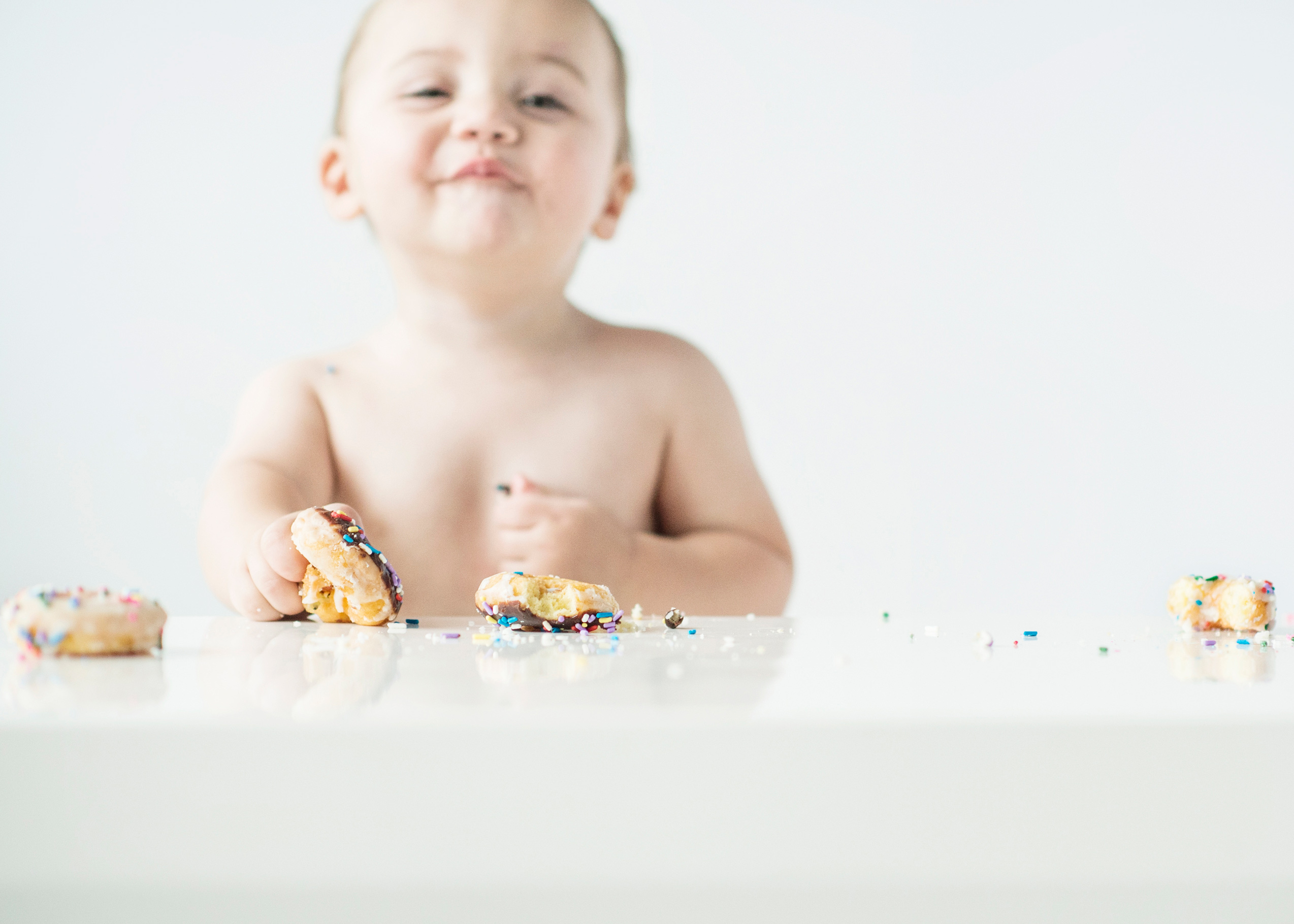 toddler eating doughnut with sprinkles
