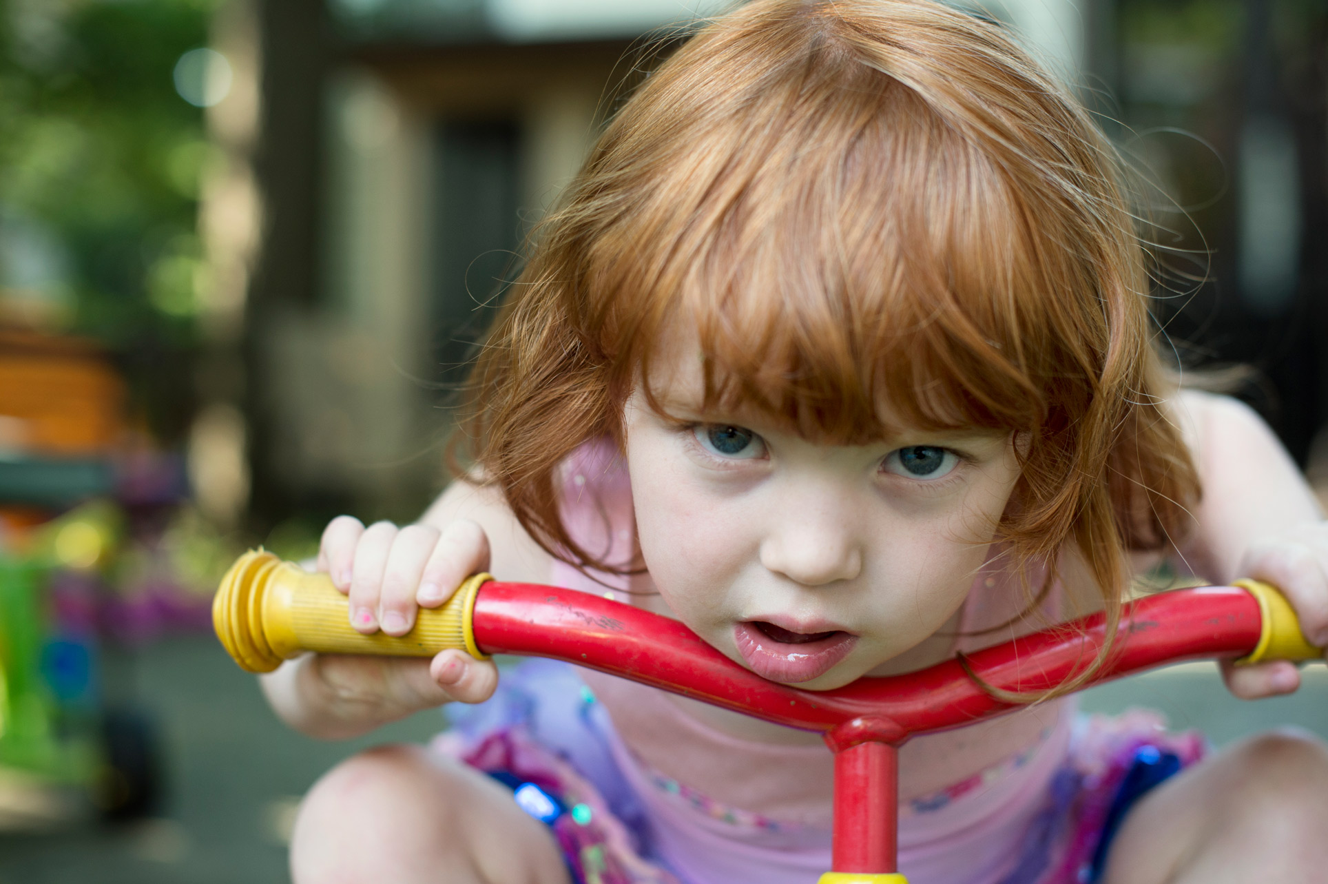 red haired girl on red tricycle