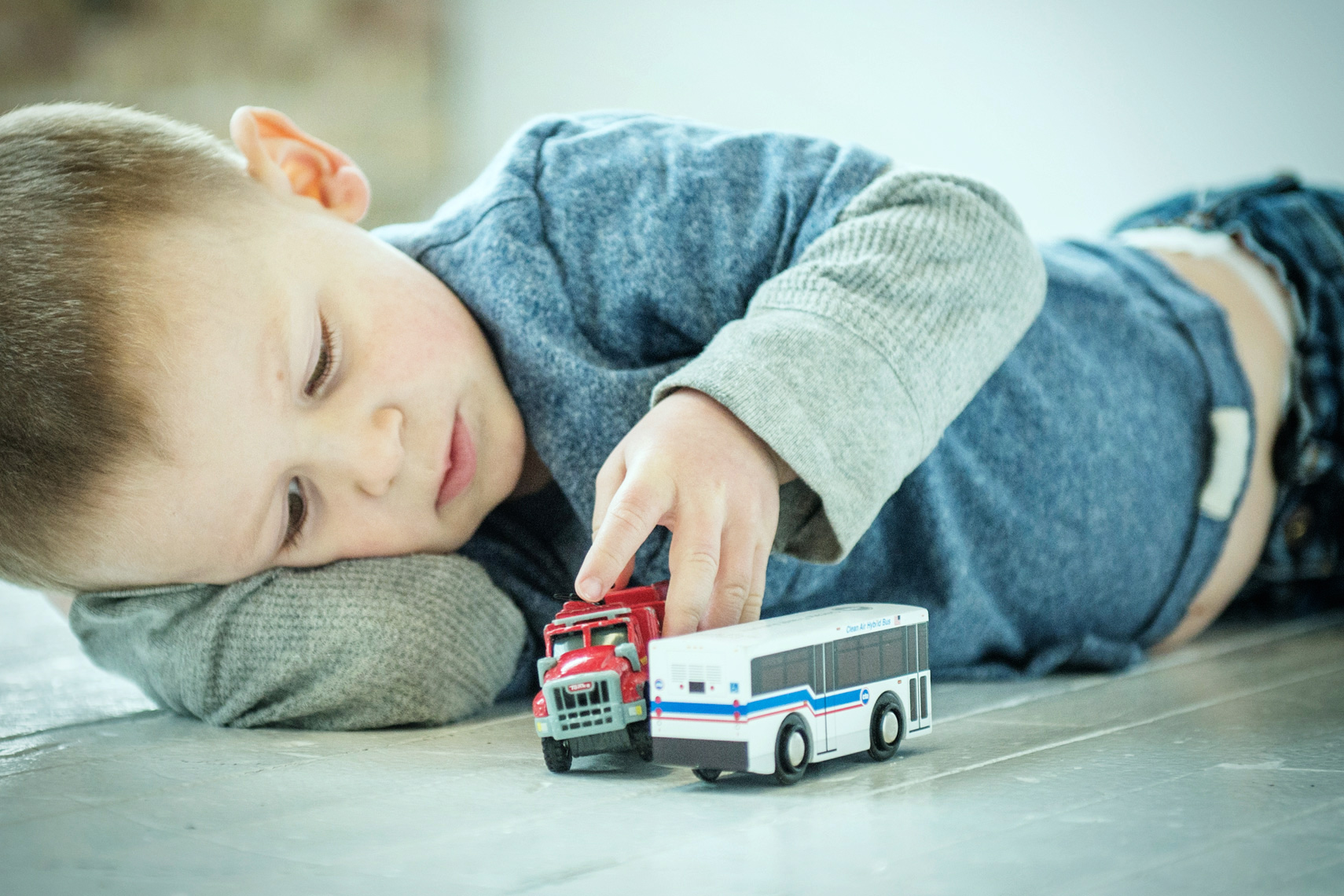 boy playing with toy bus lifestyle photography