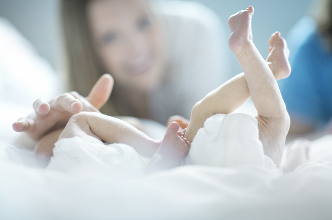 mom playing with baby twins toes