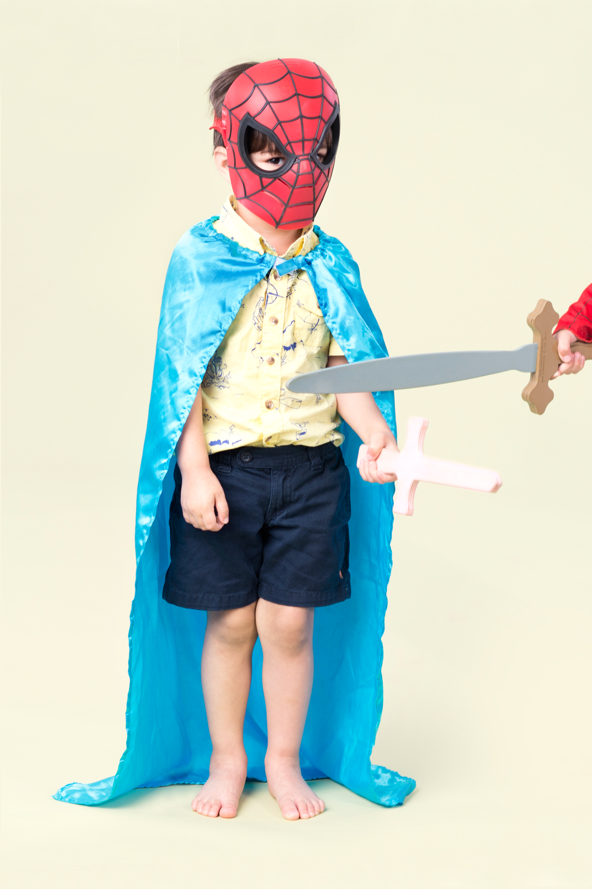 boy in spiderman mask with cape and sword
