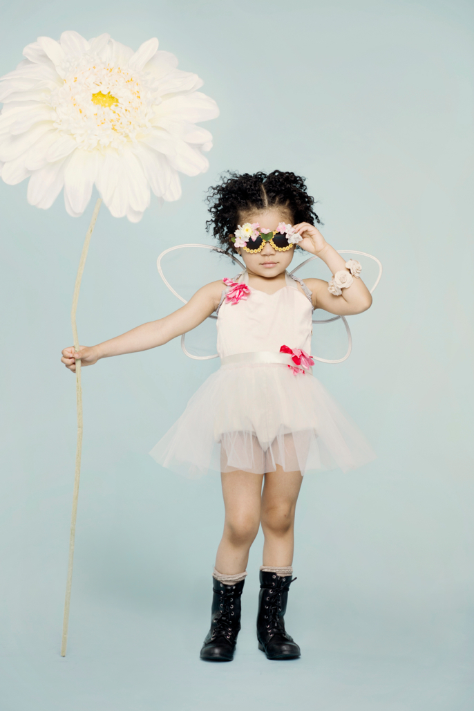 girl with giant flower and boots and sunglasses