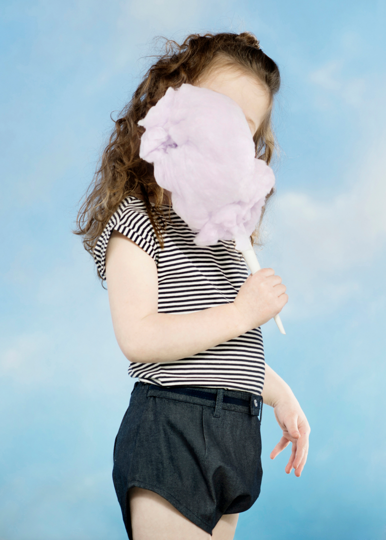 girl eating cotton candy with face obscured