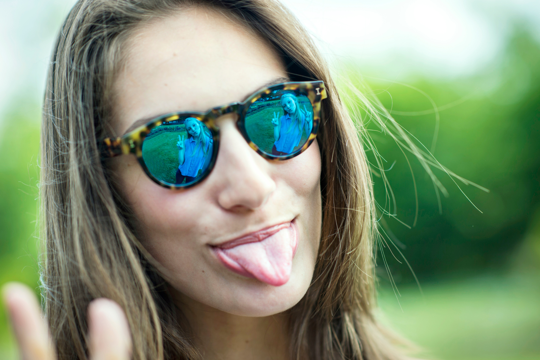 teen girl with mirror sunglasses and tongue sticking out