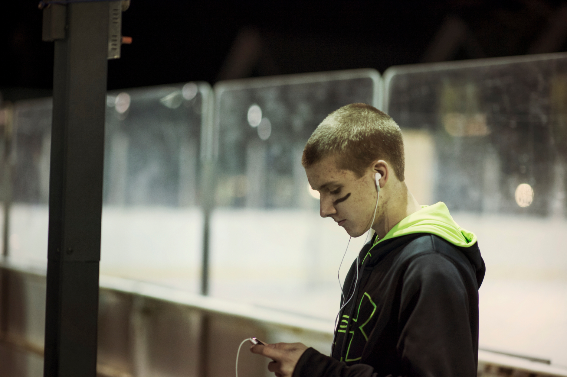 boy at hockey rink looking at phone